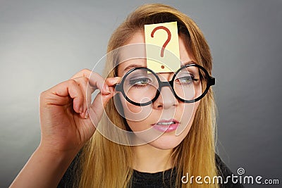 Woman having question mark on forehead thinking Stock Photo