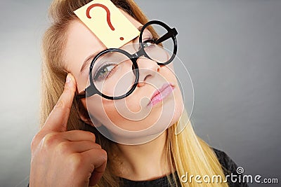Woman having question mark on forehead thinking Stock Photo