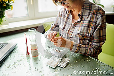 The woman having rheumatoid arthritis takes medicine. Stock Photo