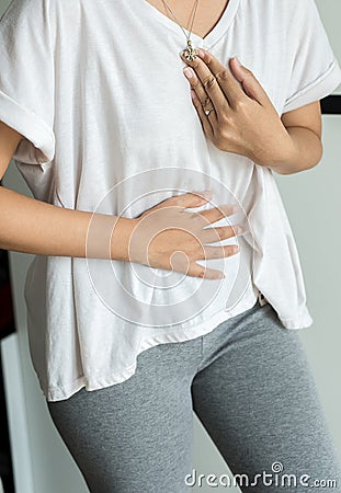 Woman having or symptomatic reflux acids,Gastroesophageal reflux disease,Because the esophageal sphincter that separates the esoph Stock Photo