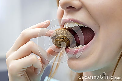 Woman with healthy tooth cracking walnut Stock Photo