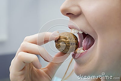 Woman with healthy tooth cracking walnut Stock Photo