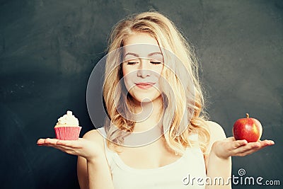 Woman with Healthy and Unhealthy Food. Difficult choice Stock Photo