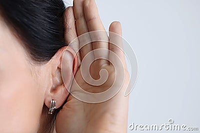 Woman held hand to ear and listened attentively. Stock Photo