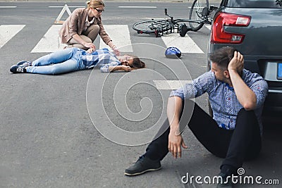 Woman helping an unconscious victim Stock Photo