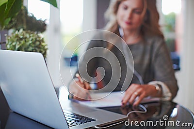 Woman at her bright cozy and beautiful home-office working on desk with laptop Stock Photo