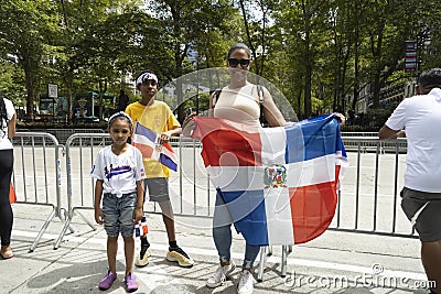 A woman and her children stand with a flag during the Dominican Day Parade Editorial Stock Photo