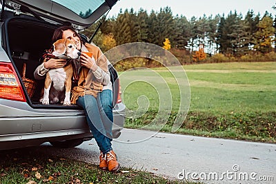 Woman with her dog have a tea time during their autumn auto travel Stock Photo