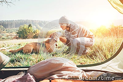 Woman and her dog tender scene near the camping tent. Active leisure, traveling with pet6 simple things concept image Stock Photo