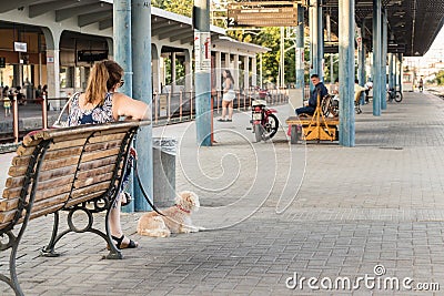 A woman with her dog waiting for the train in the platform of th Editorial Stock Photo