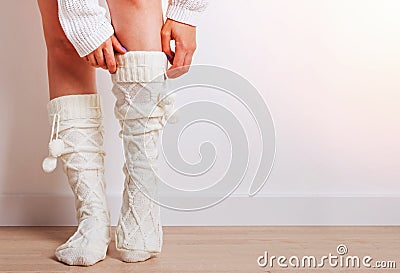 Woman with her feet close up wearing warm knitted socks in home. Stock Photo