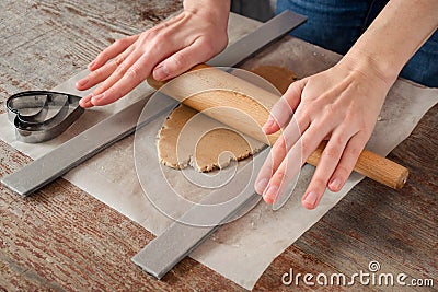 Woman with her hands rolls pastry for a cookie with a rolling pi Stock Photo