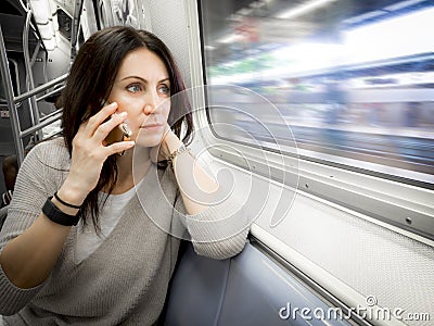 Woman in her 30s is riding the subway ans looking out the window Stock Photo