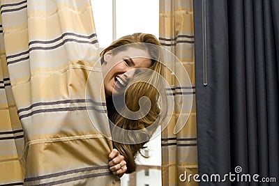 Woman Hiding Behind Curtains Stock Photo