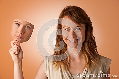 Woman hiding under the happy mask. Stock Photo