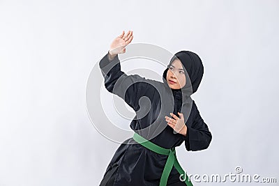 Woman in hijab in pencak silat uniform poses stance and fend off attacks with copyspace Stock Photo