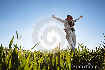 Woman hiker with backpacks walking through the grass Stock Photo