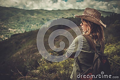 Woman hiker enjoying amazing valley landscapes on a top of mountain. Stock Photo