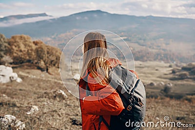 woman hiker in a jacket and with a backpack are resting in the mountains landscape Relax model Stock Photo