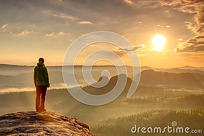 Woman hiker silhouette in mountains, sunset and fall landscape. Female hiker looking over edge at beautiful Sunset Stock Photo