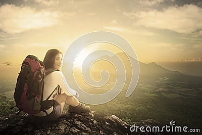 Woman hiker sitting on a mountain peak Stock Photo