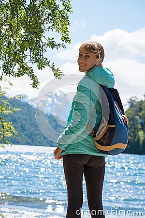 Woman hiker stands on the coast of the lake Stock Photo