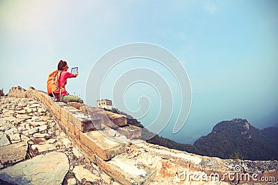 Woman hiker use digital tablet sit on chinese great wall Stock Photo