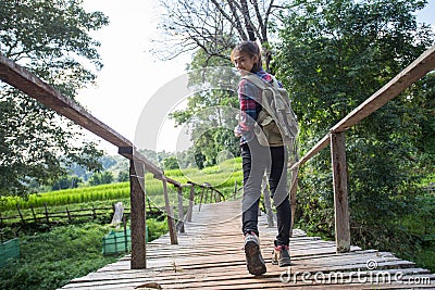 Woman hikers shoes. Female tourists walk along the bridge over the river Stock Photo