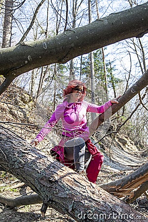 Woman hiking over a fallen tree trunks Stock Photo