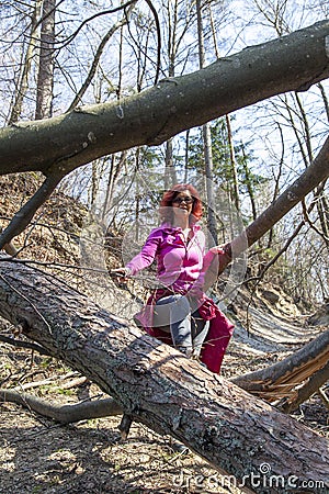 Woman hiking over a fallen tree trunks Stock Photo