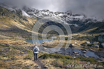 Woman hiking the tranquil trails at Tristaina Lakes, Andorra Stock Photo