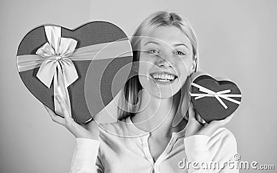 Woman hold big and little heart shaped gift boxes. Which one she prefer. Girl decide which gift she like more. Big Stock Photo