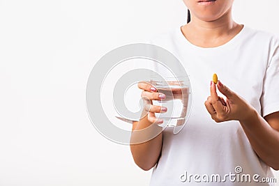 Woman hold fish oil vitamin drugs in hand ready take medicines with a glass of water Stock Photo