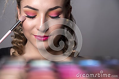 Woman hold make up pallete in the hands. Closeup of palette of an eye shadows in hands of a makeup specialist. Stock Photo