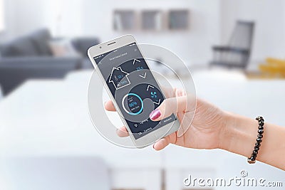 Woman hold smart phone and use smart home control app to monitoring home parameters Stock Photo