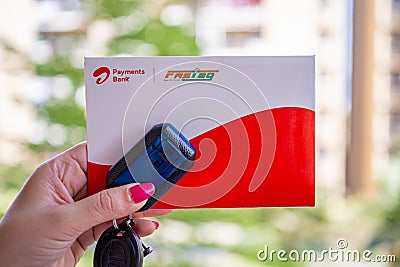 Woman holding Airtel Payment bank Fastag with car key showing the new payment method from NHAI national highway Editorial Stock Photo