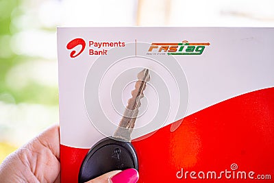 Woman holding Airtel Payment bank Fastag with car key showing the new payment method from NHAI national highway Editorial Stock Photo