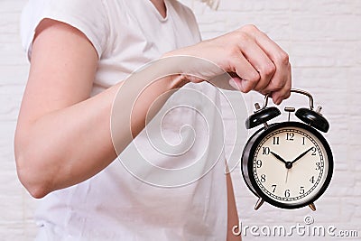 Woman holding an alarm clock showing 10 oclock, people should value and appreciate time, deadline concept Stock Photo