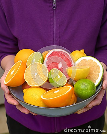Woman Holding Assorted Citrus Fruit Stock Photo