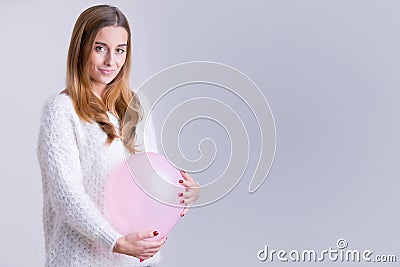 Woman Holding a Balloon to her Belly Stock Photo