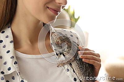 Woman holding bearded lizard indoors. Exotic pet Stock Photo