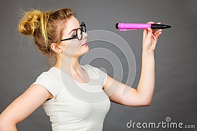 Woman holding big oversized pencil thinking about something Stock Photo