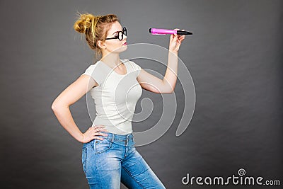 Woman holding big oversized pencil thinking about something Stock Photo