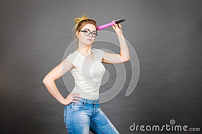 Woman holding big oversized pencil thinking about something Stock Photo