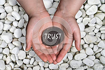 Trust word in stone on hand Stock Photo