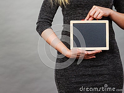 Woman holding blank black board on stomach Stock Photo