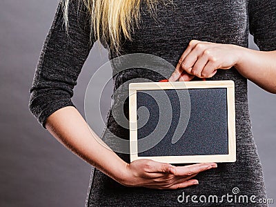 Woman holding blank black board on stomach Stock Photo