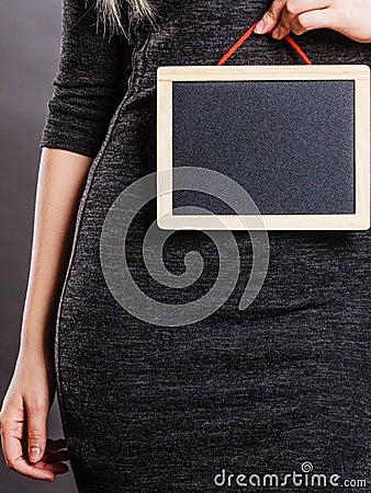 Woman holding blank black board on stomach Stock Photo