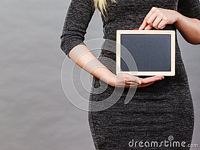 Woman holding blank black board on stomach Stock Photo