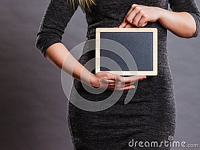 Woman holding blank black board on stomach Stock Photo